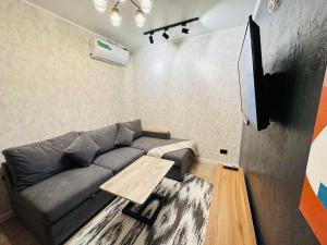a living room with a couch and a table at Yas 2 Apartment in Samarkand