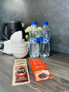 two bottles of water and a book on a table at Yas 2 Apartment in Samarkand