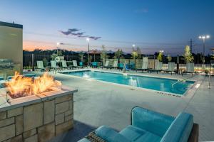 a swimming pool with a fire pit and patio furniture at SpringHill Suites by Marriott Dallas McKinney in McKinney
