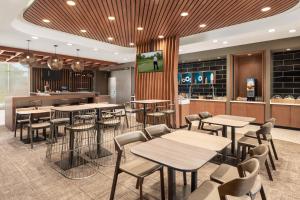 a restaurant with tables and chairs and a bar at SpringHill Suites by Marriott Milwaukee West/Wauwatosa in Wauwatosa