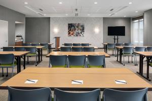 una sala conferenze con tavoli, sedie e TV di SpringHill Suites by Marriott Milwaukee West/Wauwatosa a Wauwatosa