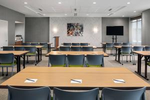 a conference room with tables and chairs and a tv at SpringHill Suites by Marriott Milwaukee West/Wauwatosa in Wauwatosa