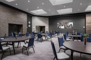 Austin Marriott North في راوند روك: غرفة طعام بها طاولات وكراسي ومسرح