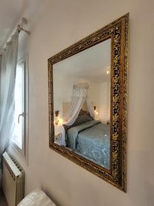 a mirror hanging on a wall in a bedroom at Cà Isabella in Venice