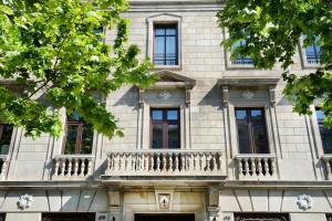 a building with a balcony on the side of it at Cotton House Hotel, Autograph Collection in Barcelona