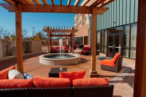 a patio with a fountain and chairs and a pergola at Courtyard Warner Robins in Warner Robins