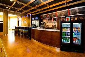 eine Bar in einem Restaurant mit Getränkekühler in der Unterkunft Courtyard Warner Robins in Warner Robins
