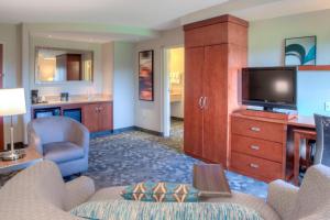 a living room with a couch and a tv and a kitchen at Courtyard Mobile Spanish Fort/Eastern Shore in Spanish Fort