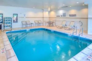 a pool with chairs and tables in a hotel room at Courtyard Mobile Spanish Fort/Eastern Shore in Spanish Fort