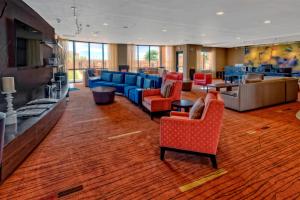 a lobby with blue and red chairs and tables at Courtyard by Marriott Midland in Midland