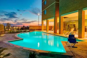 a swimming pool in front of a building at Courtyard by Marriott Dallas Carrollton and Carrollton Conference Center in Carrollton