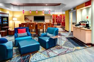 TownePlace Suites by Marriott Bakersfield West في بيكرسفيلد: غرفة انتظار مع كراسي زرقاء ومطبخ