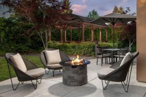 a patio with chairs and a fire pit and a gazebo at Courtyard Chico in Chico