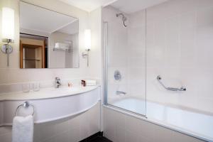 a bathroom with a tub and a sink and a shower at Sheraton Brussels Airport Hotel in Zaventem
