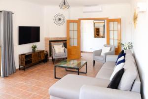 sala de estar con sofá y TV en Casa Rina, en Lagoa