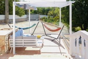 - une terrasse couverte blanche avec un hamac et un parasol dans l'établissement Casa Rina, à Lagoa