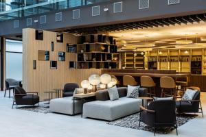 a lobby with couches and chairs and a bar at AC Hotel by Marriott Bratislava Old Town in Bratislava