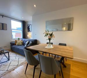 a living room with a table and a blue couch at New stylish Fulham apartment - 2 bed in London