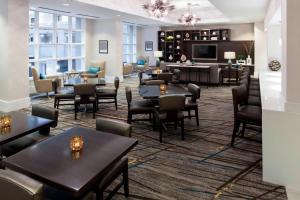 un restaurant avec des tables et des chaises ainsi qu'un bar dans l'établissement Fairfax Marriott at Fair Oaks, à Fairfax