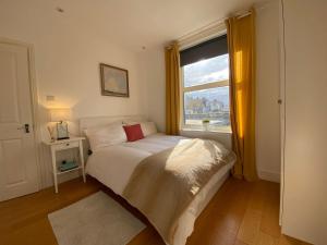 Habitación pequeña con cama y ventana en New stylish Fulham apartment - 2 bed, en Londres