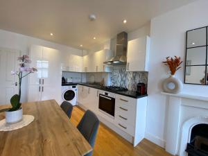 cocina con mesa de comedor y chimenea en New stylish Fulham apartment - 2 bed, en Londres