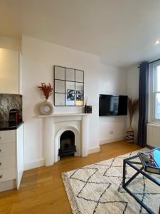 sala de estar con chimenea y TV en New stylish Fulham apartment - 2 bed, en Londres