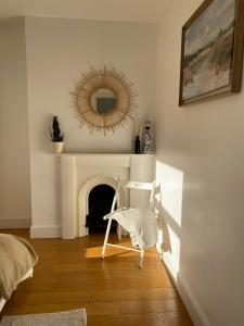 - un salon avec une chaise et une cheminée dans l'établissement New stylish Fulham apartment - 2 bed, à Londres