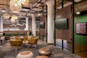 a lobby with couches and chairs and a tv at Element Moline in Moline