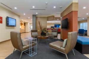 eine Lobby mit Stühlen, einem Tisch und einem TV in der Unterkunft TownePlace Suites by Marriott McAllen Edinburg in Edinburg