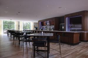 a bar with chairs and tables in a restaurant at Courtyard by Marriott Iowa City University Heights in Iowa City