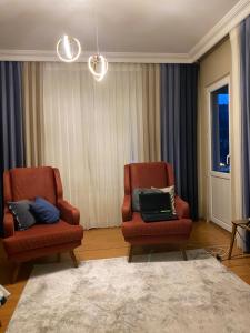 sala de estar con 2 sillas y ordenador portátil en İstanbul Otel Süit, en Estambul