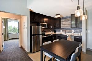 uma cozinha com uma mesa de madeira e um frigorífico em Residence Inn by Marriott Cincinnati Northeast/Mason em Mason