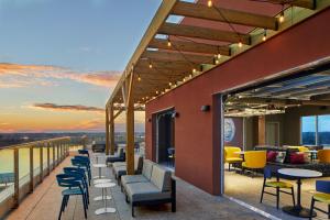 a row of chairs and tables on a balcony at Aloft Wilmington at Coastline Center in Wilmington