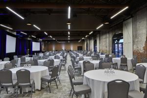ウィルミントンにあるAloft Wilmington at Coastline Centerの白いテーブルと椅子が備わる宴会場