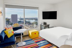 ウィルミントンにあるAloft Wilmington at Coastline Centerのベッドと大きな窓が備わるホテルルームです。