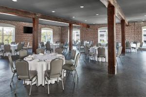 uma sala de jantar com mesas e cadeiras e paredes de tijolos em Aloft Wilmington at Coastline Center em Wilmington