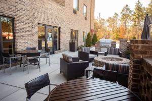 a patio with chairs and tables and a brick building at TownePlace Suites by Marriott Southern Pines Aberdeen in Aberdeen