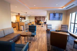 una sala de espera con muebles y TV de pantalla plana. en TownePlace Suites by Marriott Southern Pines Aberdeen, en Aberdeen