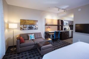 a living room with a couch and a desk in a room at TownePlace Suites by Marriott Southern Pines Aberdeen in Aberdeen