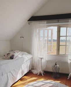 1 dormitorio con cama y ventana en Knappagården, en Glemminge