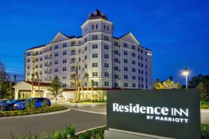 a white building with a sign in front of it at Residence Inn by Marriott Orlando at FLAMINGO CROSSINGS Town Center in Orlando