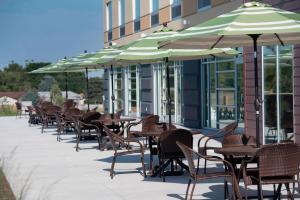a row of tables and chairs with umbrellas on a patio at Fairfield Inn & Suites by Marriott Scottsbluff in Scottsbluff