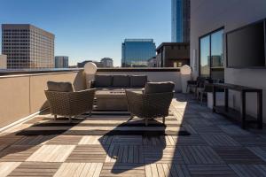 einen Balkon mit Sofa und Stühlen auf einem Gebäude in der Unterkunft Aloft Atlanta at The Battery Atlanta in Atlanta