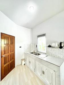 a kitchen with a sink and a wooden door at Lay Back Villa C3 with Kitchen & High Speed Internet in Ban Laem Som +19 photos