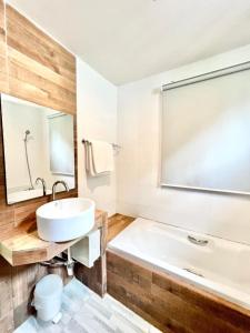 a bathroom with a white tub and a sink at Lay Back Villa C3 with Kitchen & High Speed Internet in Ban Laem Som