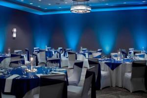 a room filled with tables and chairs with blue lights at Atlanta Marriott Peachtree Corners in Norcross