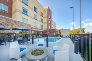 a patio with a table and chairs and a pool at Fairfield Inn & Suites by Marriott Charlotte Belmont in Belmont