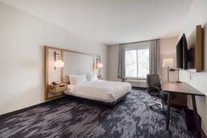 a hotel room with a bed and a desk at Fairfield Inn & Suites by Marriott Charlotte Belmont in Belmont