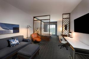 a living room with a couch and a desk in a hotel room at Courtyard by Marriott Charlotte Waverly in Charlotte