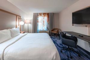 a hotel room with a large bed and a desk at Fairfield Inn by Marriott Evansville West in Evansville